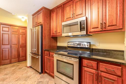 Rich wood cabinetry, granite countertops, and stainless steel appliances combine to create a stylish and functional kitchen.
