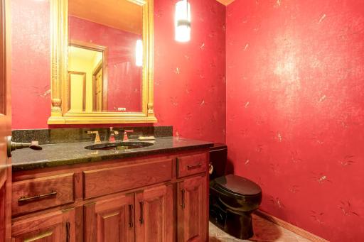 Convenient main-level powder room featuring a granite-top vanity and updated finishes.