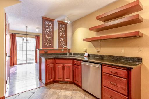 Functional kitchen with abundant counter space, custom floating shelves, and a seamless connection to the dining area.