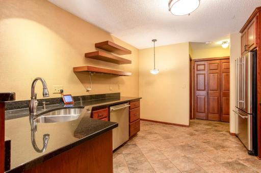 Updated kitchen featuring granite countertops, stainless steel appliances, abundant cabinetry, and generous prep space.
