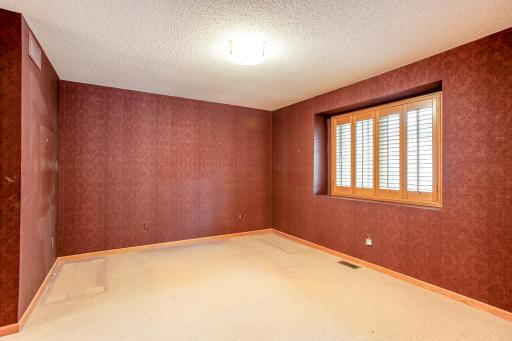 Spacious primary bedroom featuring abundant natural light, plantation shutters, and plenty of room for a king-size bed and additional furnishings.