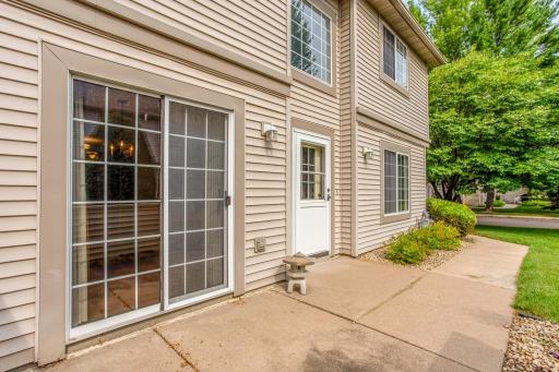 Private patio bordered by mature landscaping offers a quiet space to unwind while enjoying the beautifully maintained community.
