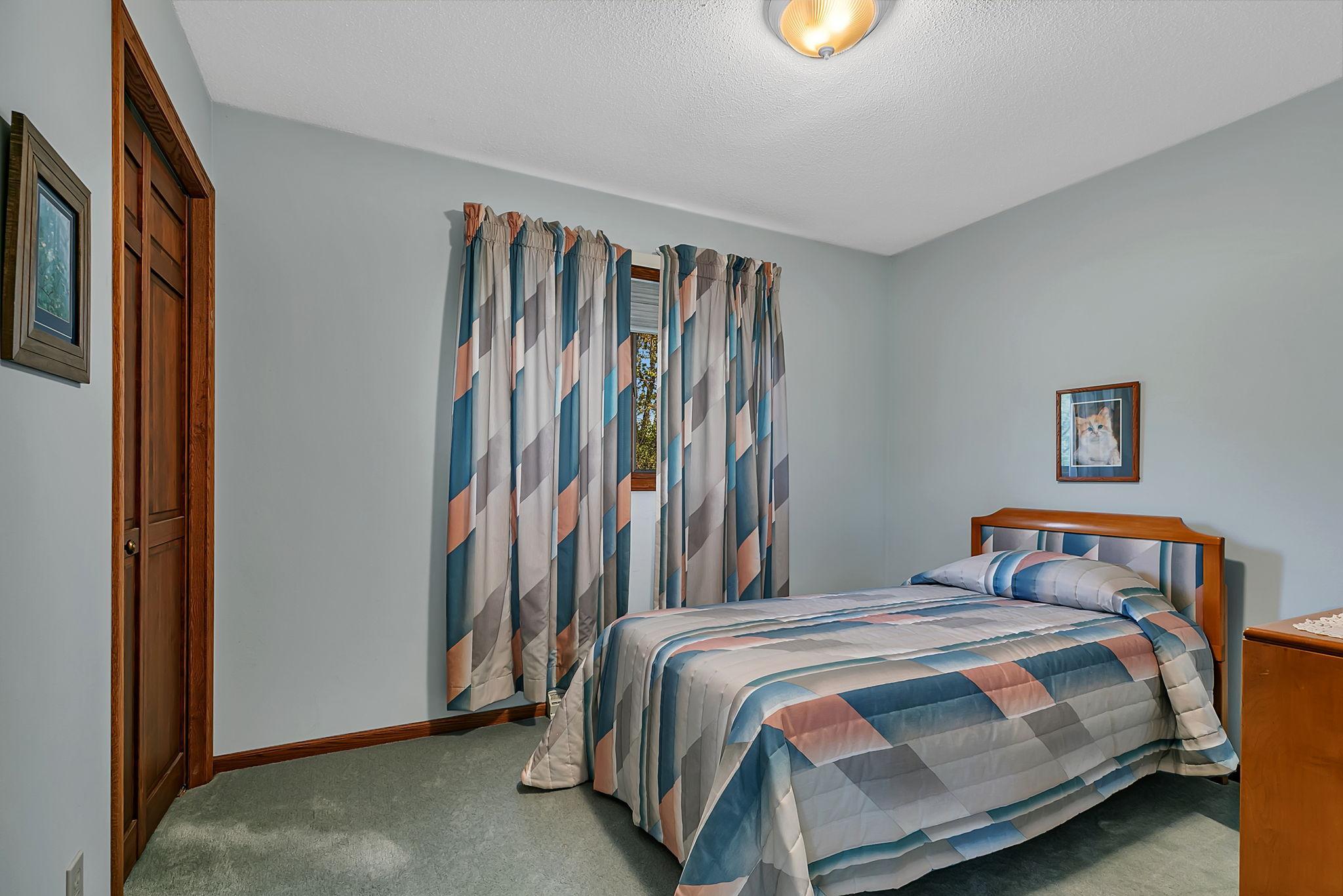 Another upper level bedroom with plush carpeting.