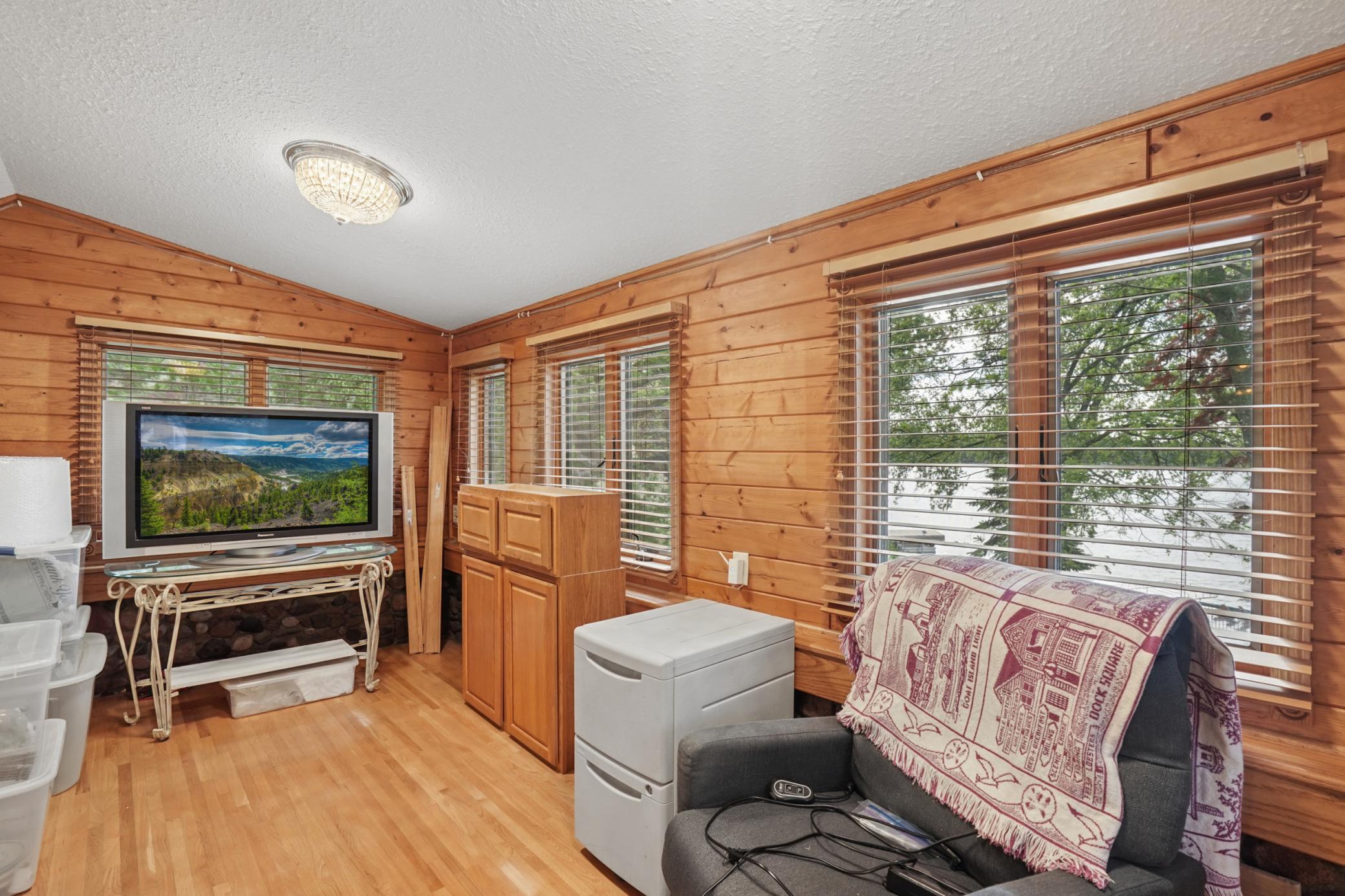 The family room with large picture windows overlooking Cedar Lake with floor to ceiling tongue and groove knotty pine.