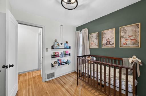 Spacious main-level bedroom with hardwood floors and versatile layout options.