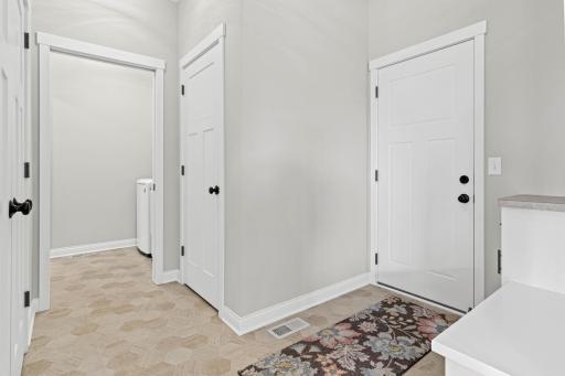 Garage entrance features easily-to-maintain flooring, abundant storage closets and the laundry.