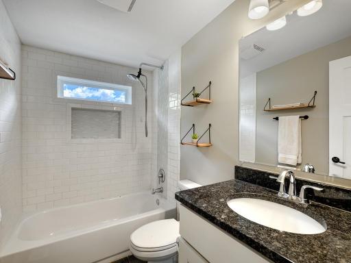 The full upper bathroom boasts granite counters and stylish tile work.