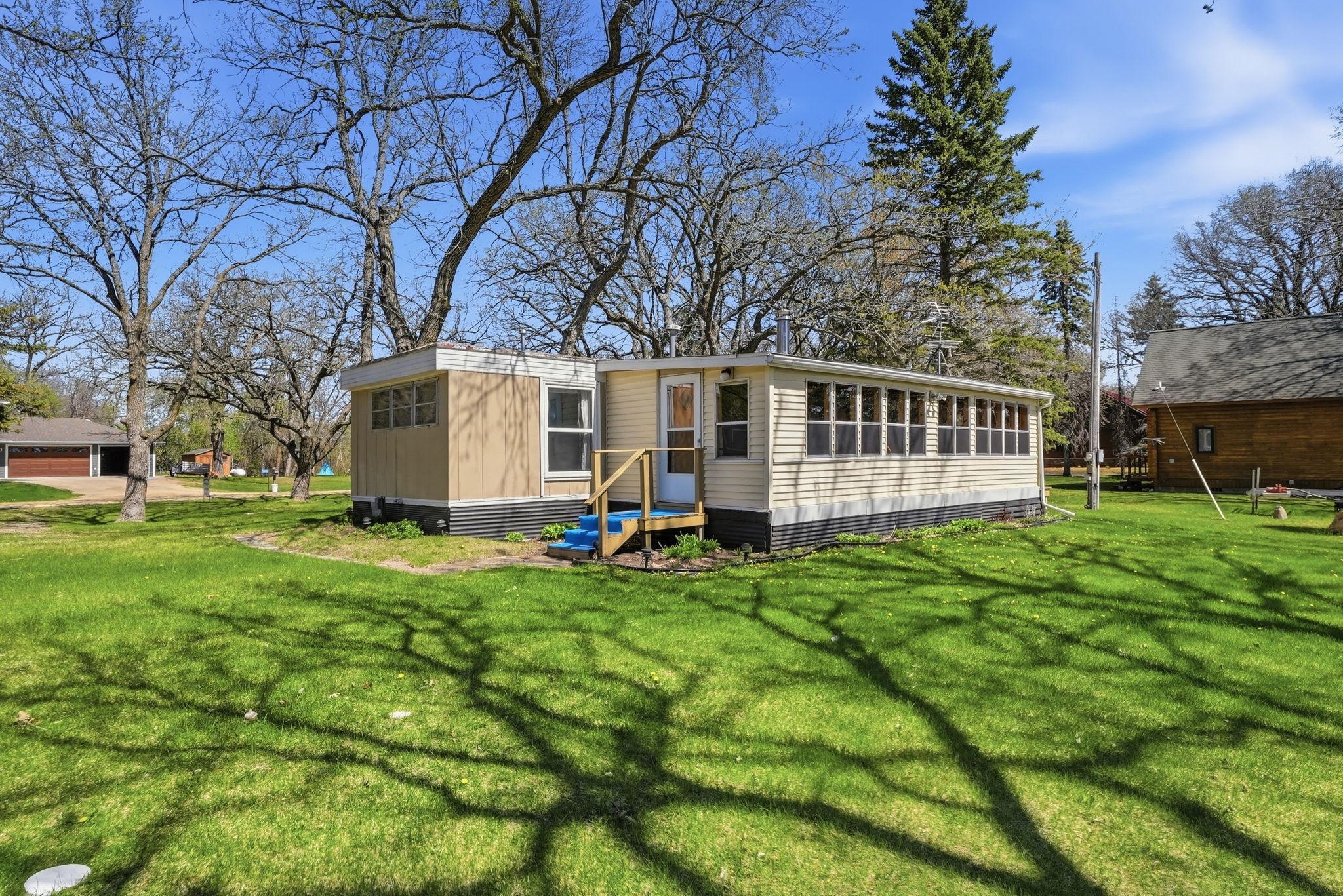 15439 Dittberners Creek Road NW Miltona MN Year round cabin 2 bedrooms, 3 season porch, garage, bunk house, storage shed and don't miss the tree house all canopied with mature trees on a level Lake Miltona lot .