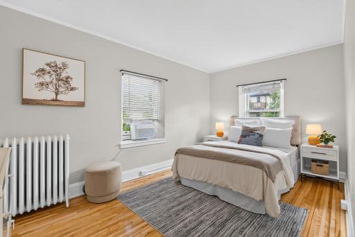 Primary bedroom with tons of natural light and beautiful refinished hardwood floors!