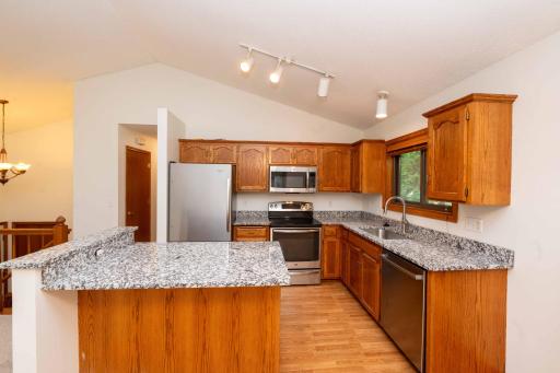 The open kitchen features new granite countertops, stainless steel appliances, and a center island.