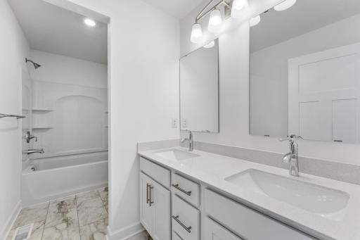 This full bathroom is conveniently located on the second floor and showcases dual sinks and a shower-tub combination.