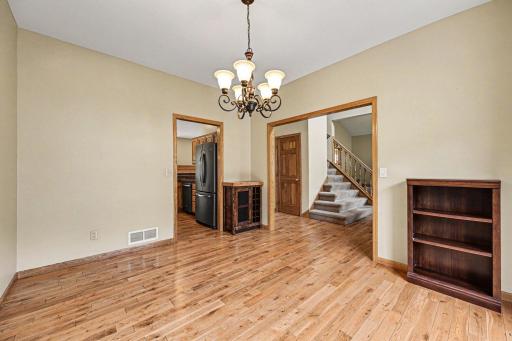 Perfect for entertaining! This view highlights the seamless main floor layout, showcasing the formal dining room's convenient proximity to the kitchen, alongside the beautiful entryway staircase and front coat closet.