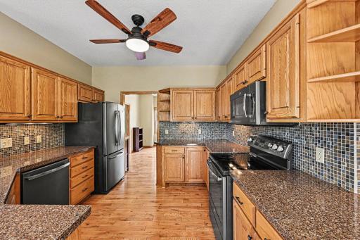 This view highlights the ample counter and cabinet space! Equipped with GE stainless-steel appliances (glass-top stove, fridge, dishwasher, microwave), a deep double sink with pull-down faucet, and a disposalâall your needs are met!