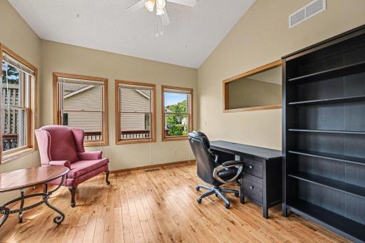 Sunshine everywhere! This shot of the versatile sunroom or home office demonstrates how the brilliant natural light filters directly into the formal living room through the architectural wall opening.