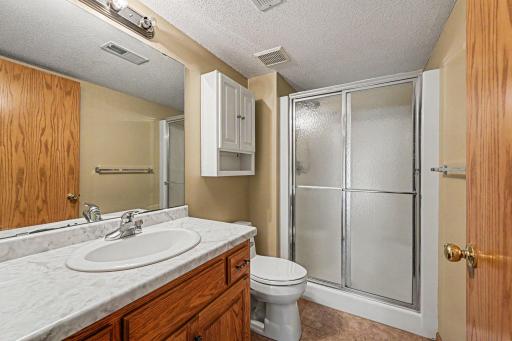 The lower level includes a convenient 3/4 bathroom with ceramic tile floors, vanity with storage, and a shower.