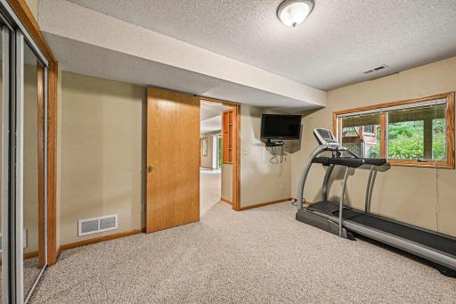 Just off the family room is bedroom four. It features a large window & two spacious closets. It currently being used as a workout room.