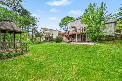 Another view highlighting the spacious yard, private gazebo, and expansive deck and patio spaces. Enjoy endless peace and quiet, as the property directly butts up to Golfview Park East and wide-open soccer fields!