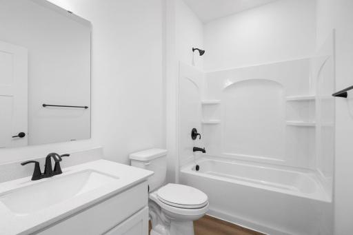 This full-sized bathroom is between the secondary bedrooms and features a single vanity and a shower-tub combination.
