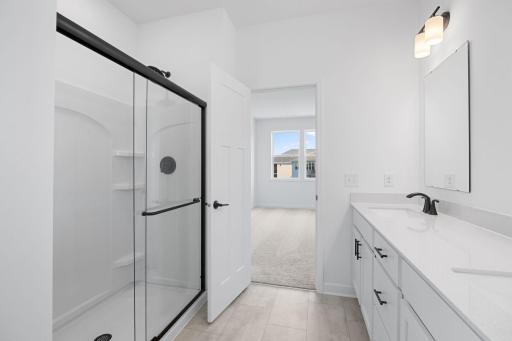 The glass-enclosed shower with full tile surround adds to a spa-like environment