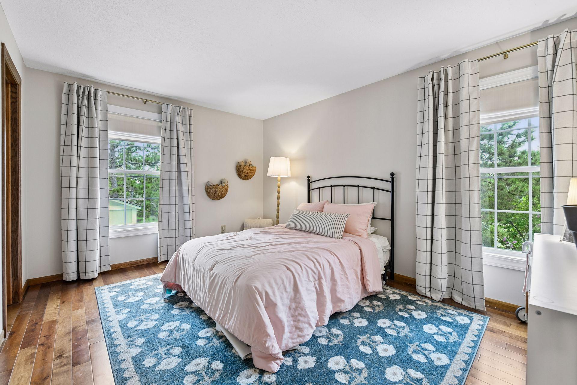 The primary suite enjoys beautiful hardwood floors and a spacious walk-in closet.