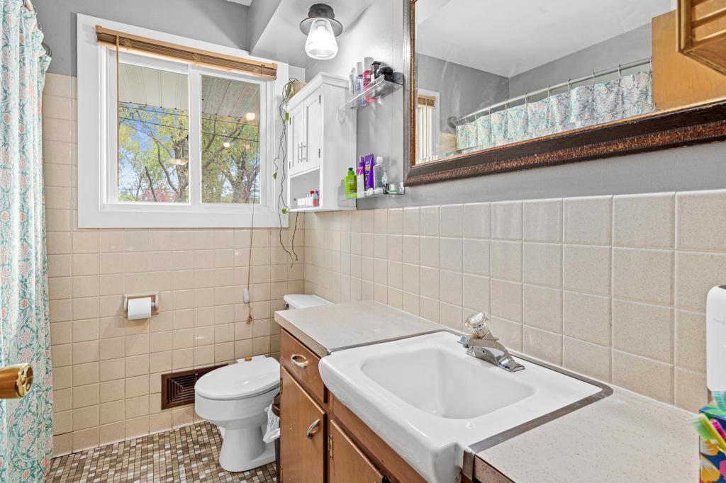 Full main level bathroom with functional layout and convenient access. Window to the backyard provides additional light.