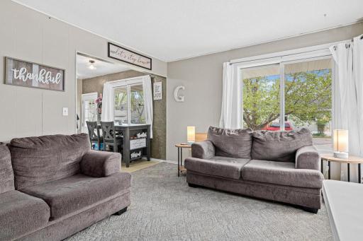 Spacious, inviting living room on the other side of the duplex. Hardwood floors under the carpet - add instant appeal by removing the carpet and exposing the floors. Newer windows throughout the duplex.