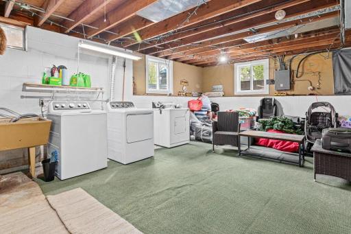 Expansive unfinished lower level in the second unit currently used as laundry and utility space.