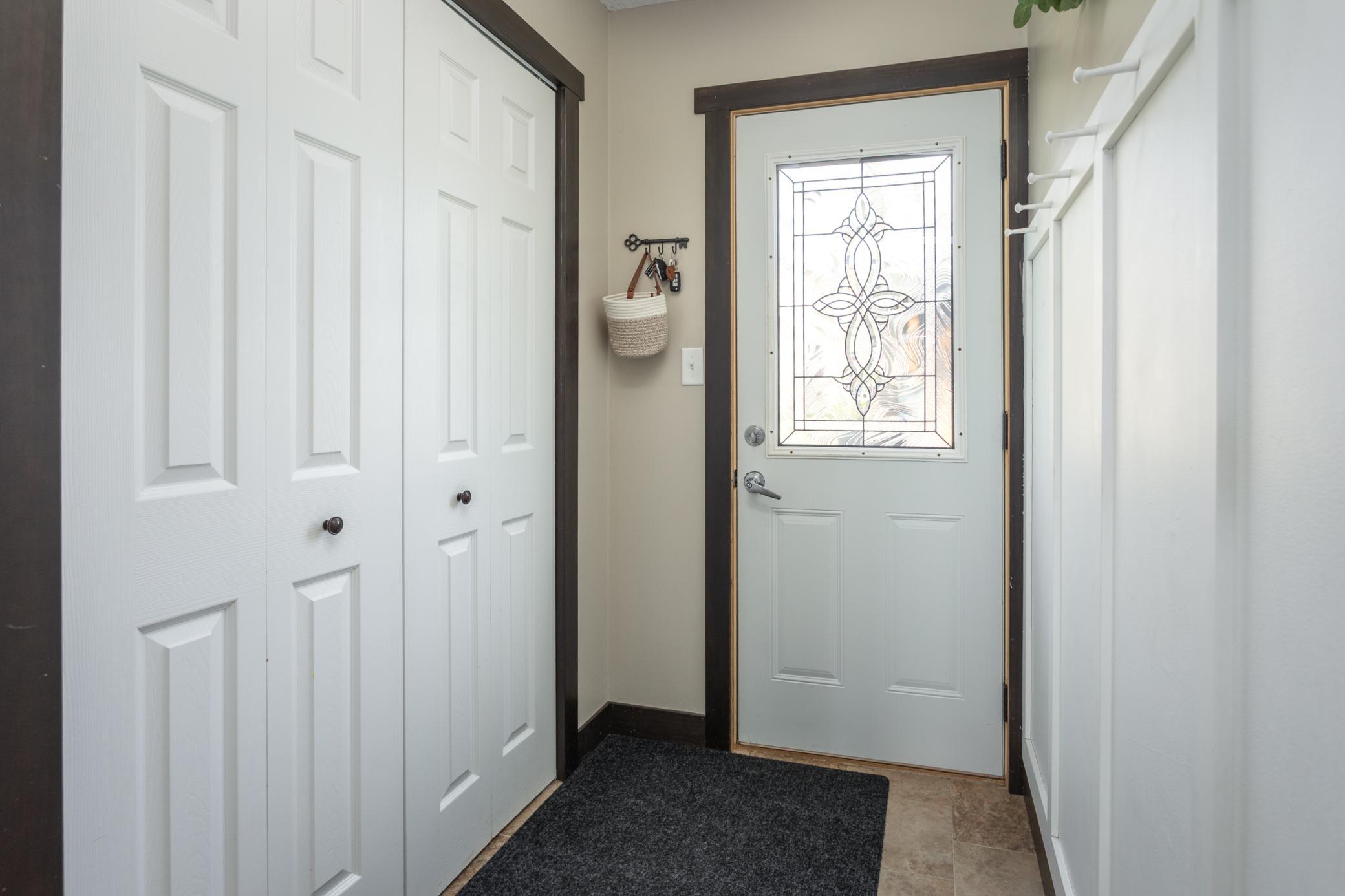 Charming entryway with convenient wall hooks and a closet for easy organization.
