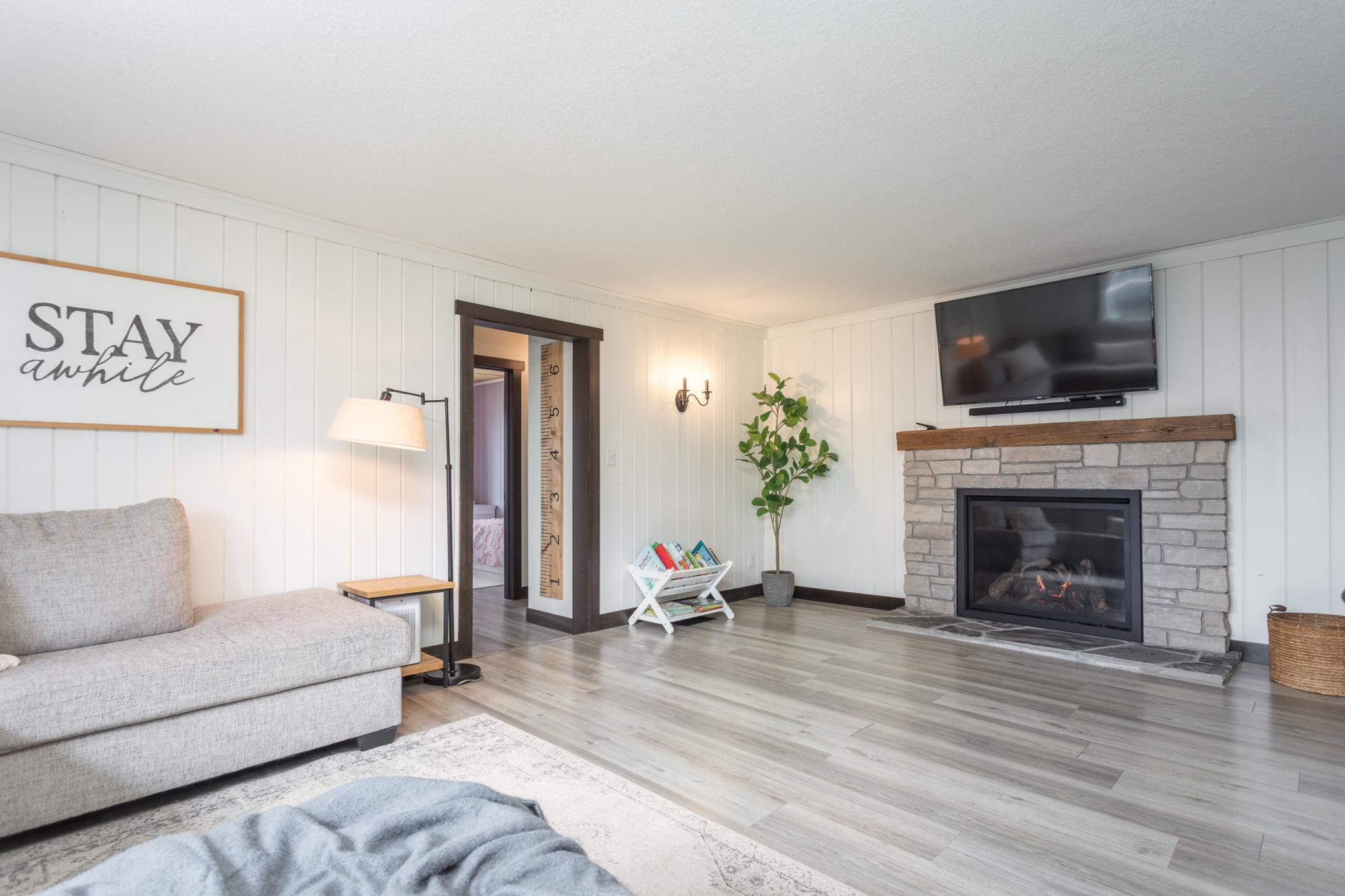 The living room has a cozy fireplace and TV, perfect for relaxing or entertaining.