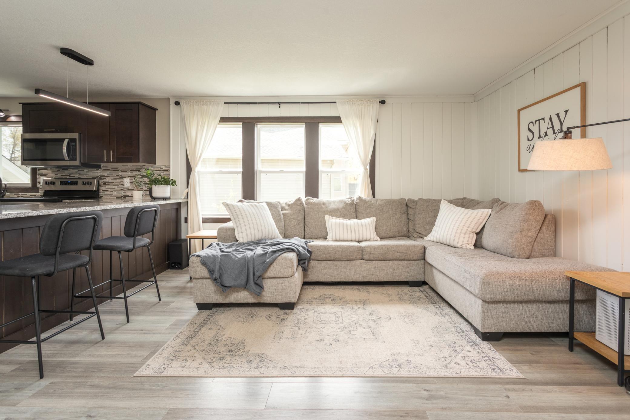 Bright and inviting living room with white paneling and a large window that fills the space with natural light.