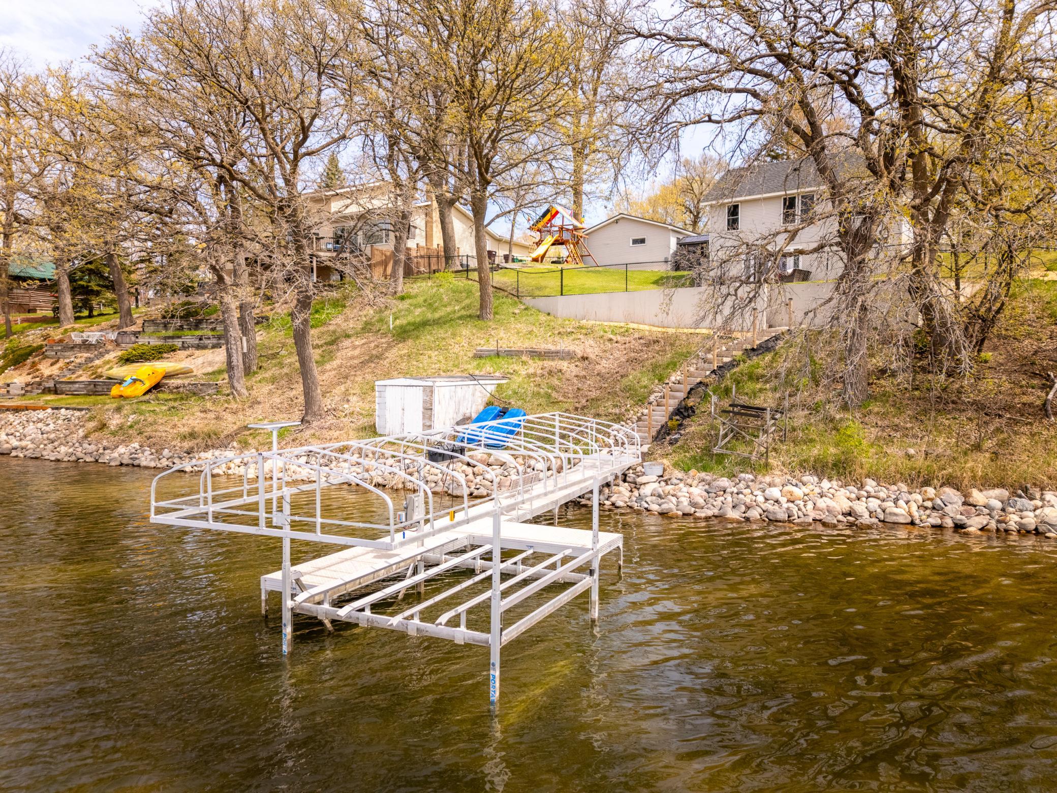 erial view from the lake, showcasing the back of the home along with the dock and lift.