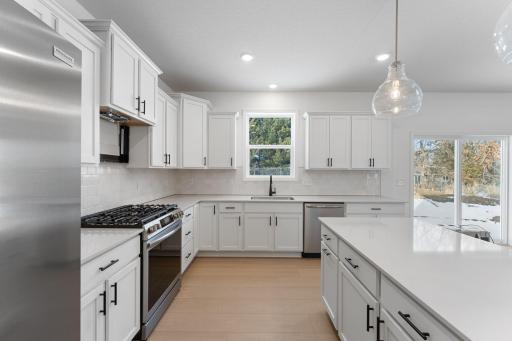 (Photo of a similar home, actual finishes may vary) This stylish and multifunctional kitchen comes complete with brand-new stainless steel appliances, sleek quartz countertops and Shaker-style cabinetry.