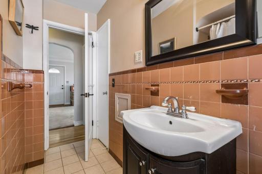This bathroom has vintage tile work and a oversized closet with loads of storage. There is also a built in linen closet in the hallway.