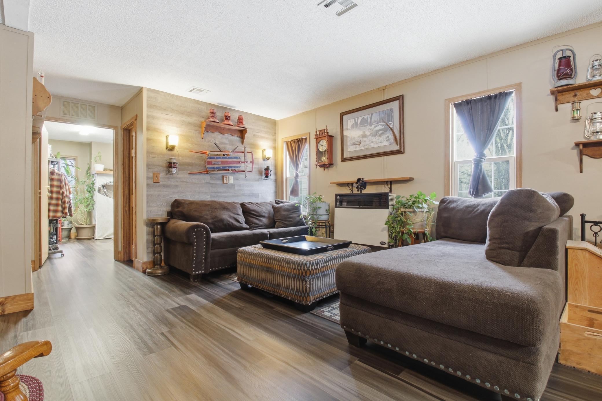 An inviting living room featuring a cozy wood stove and an additional wall heating unit for comfortable living in every season.