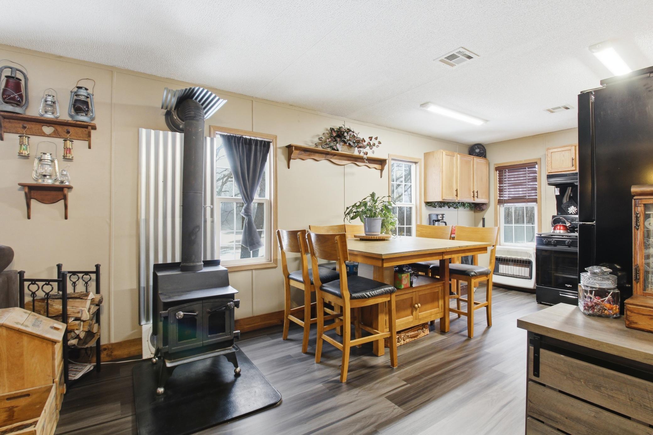 Comfortable dining space with nearby wood stove adds warmth and charm to the open kitchen and living area