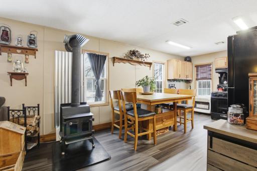 Comfortable dining space with nearby wood stove adds warmth and charm to the open kitchen and living area