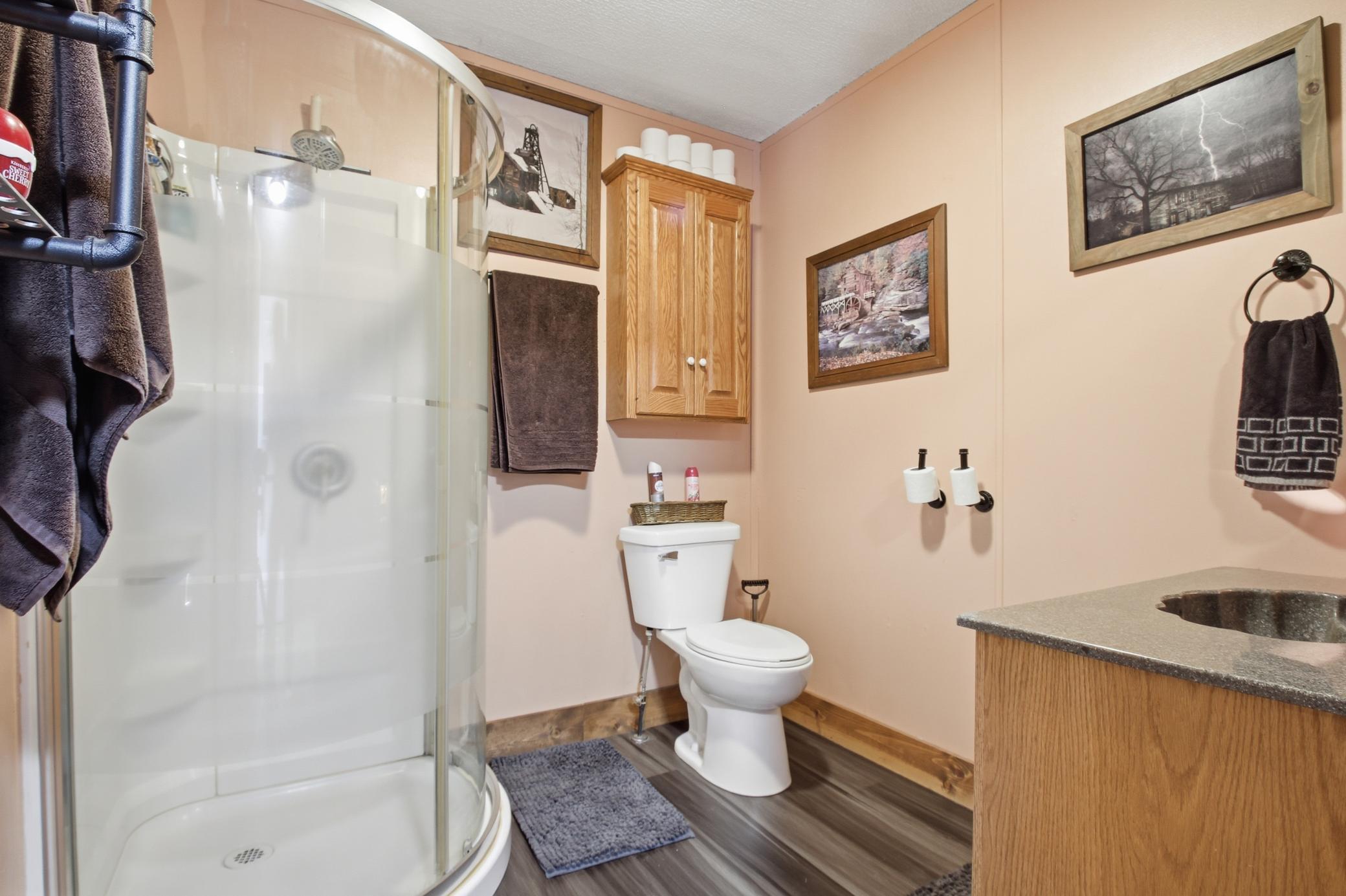 Full bathroom featuring a corner shower and a convenient storage cabinet.