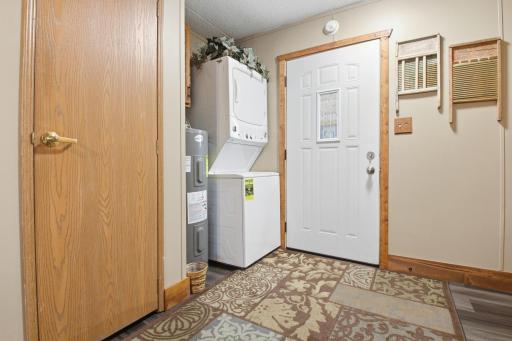 Entry area with stacked washer and dryer for convenient laundry access.