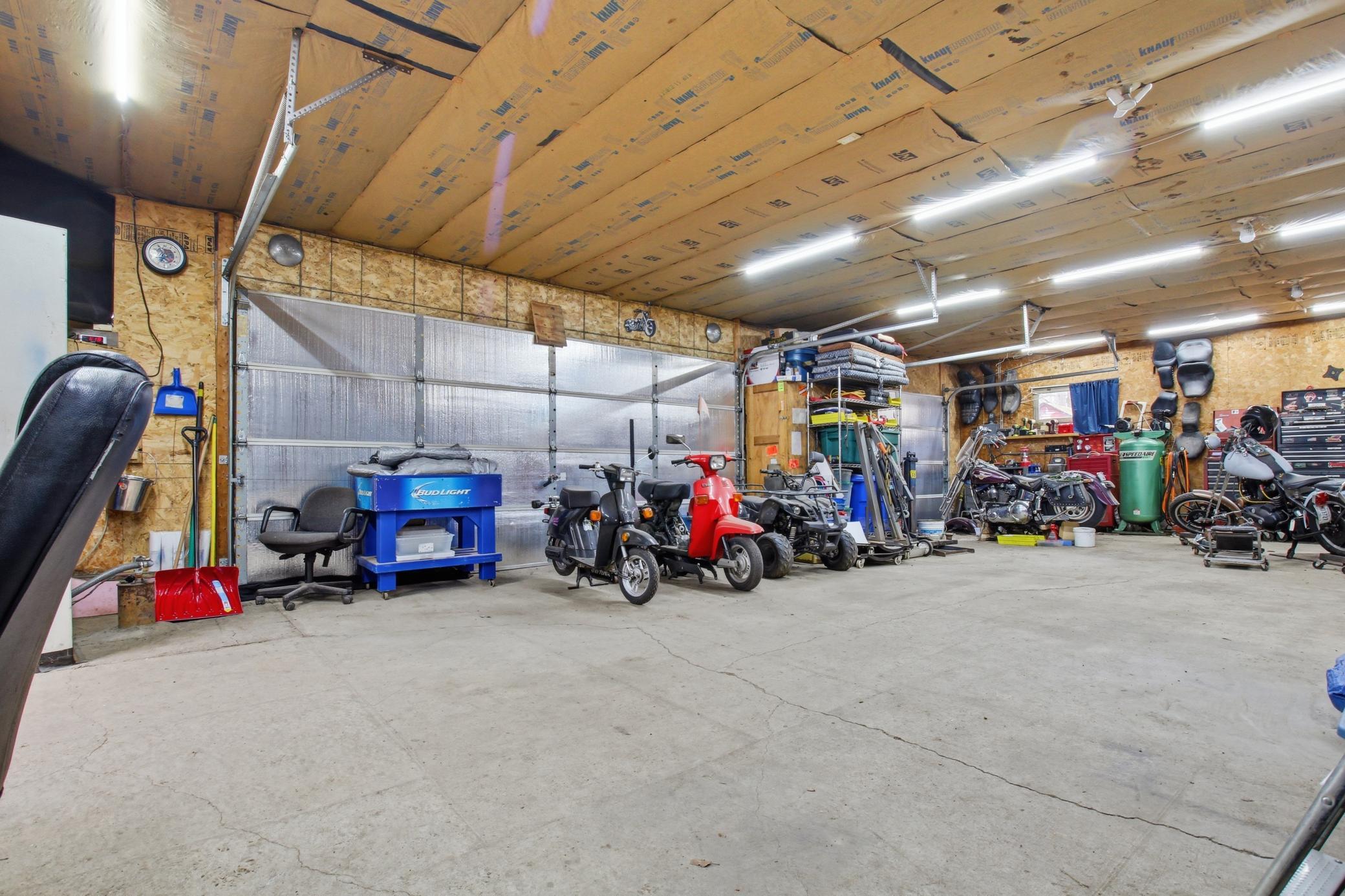 Expansive garage interior with room for vehicles, recreational toys, and workshop space