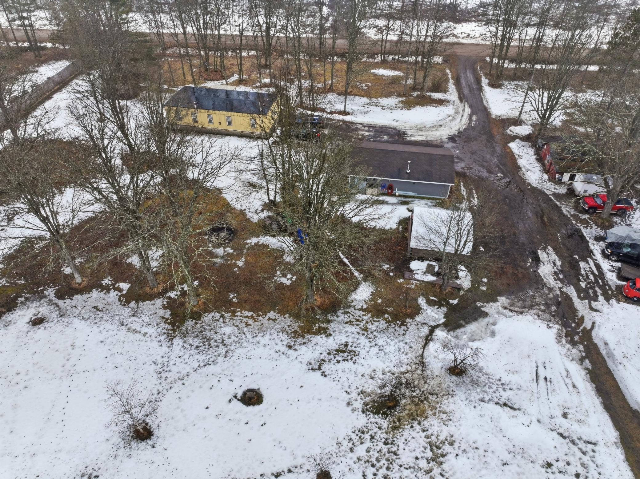 Aerial view showing the home, outbuildings, and open yard space.