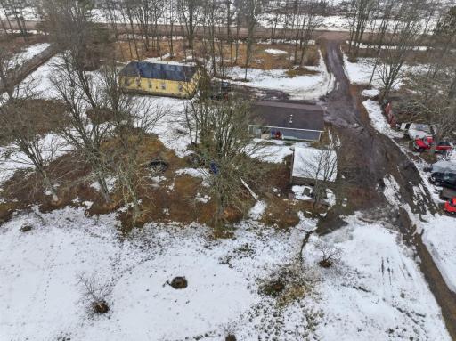 Aerial view showing the home, outbuildings, and open yard space.