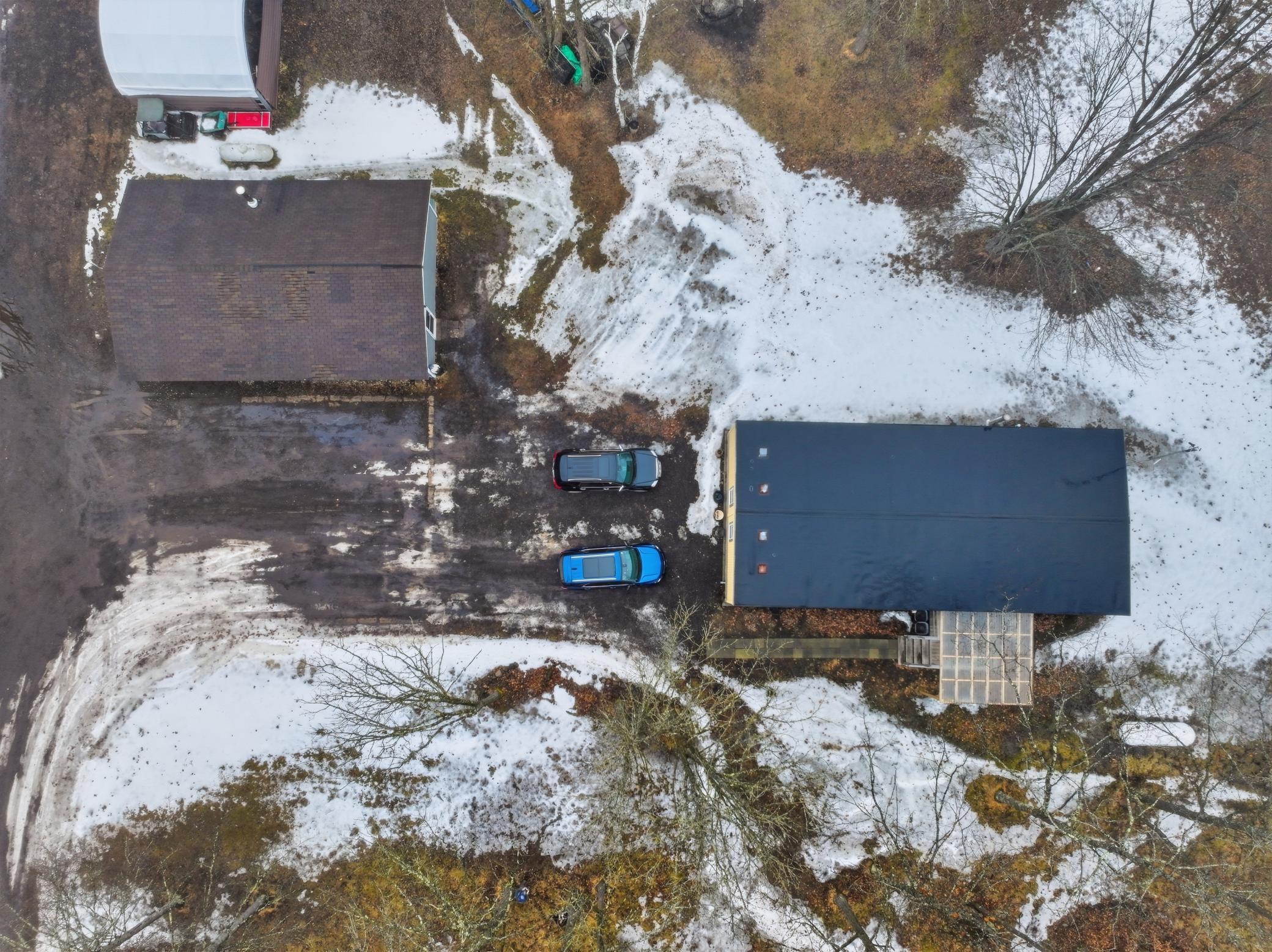 “Top-down aerial view showing the layout of the home, garage, and surrounding yard.”