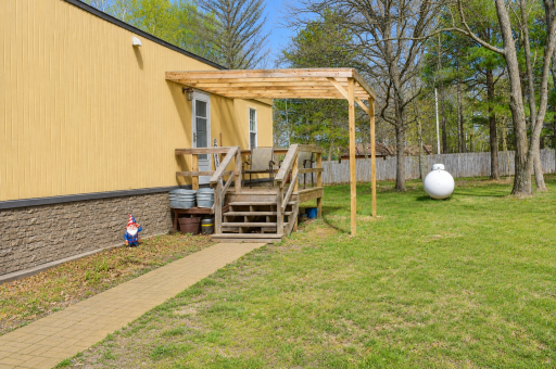 A welcoming covered entry with a pergola-style porch creates a cozy place to relax and enjoy the peaceful wooded setting in Onamia.