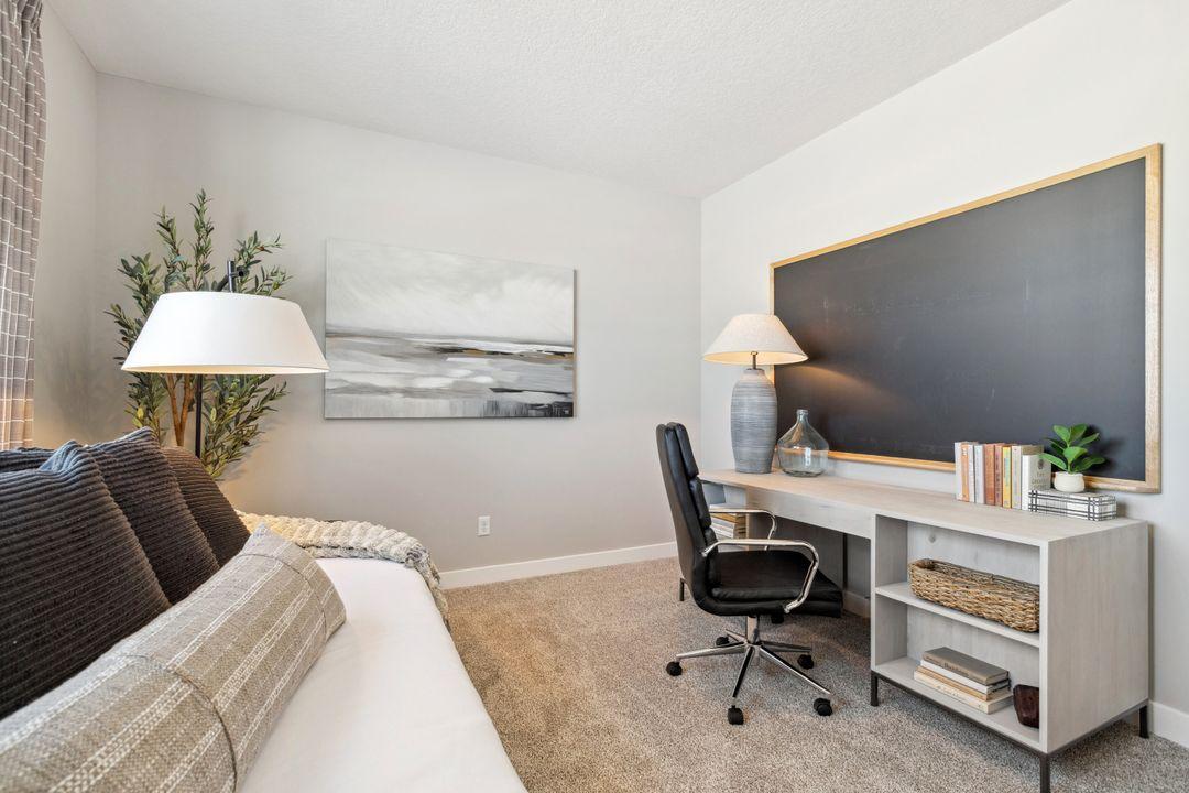 Tucked back off the home's mudroom, away from the hustle and bustle of the main level living spaces, this bedroom resides adjacent to a 3/4 bath & serves as the perfect guest room or your home office! Photo of a model home, color & options will vary.