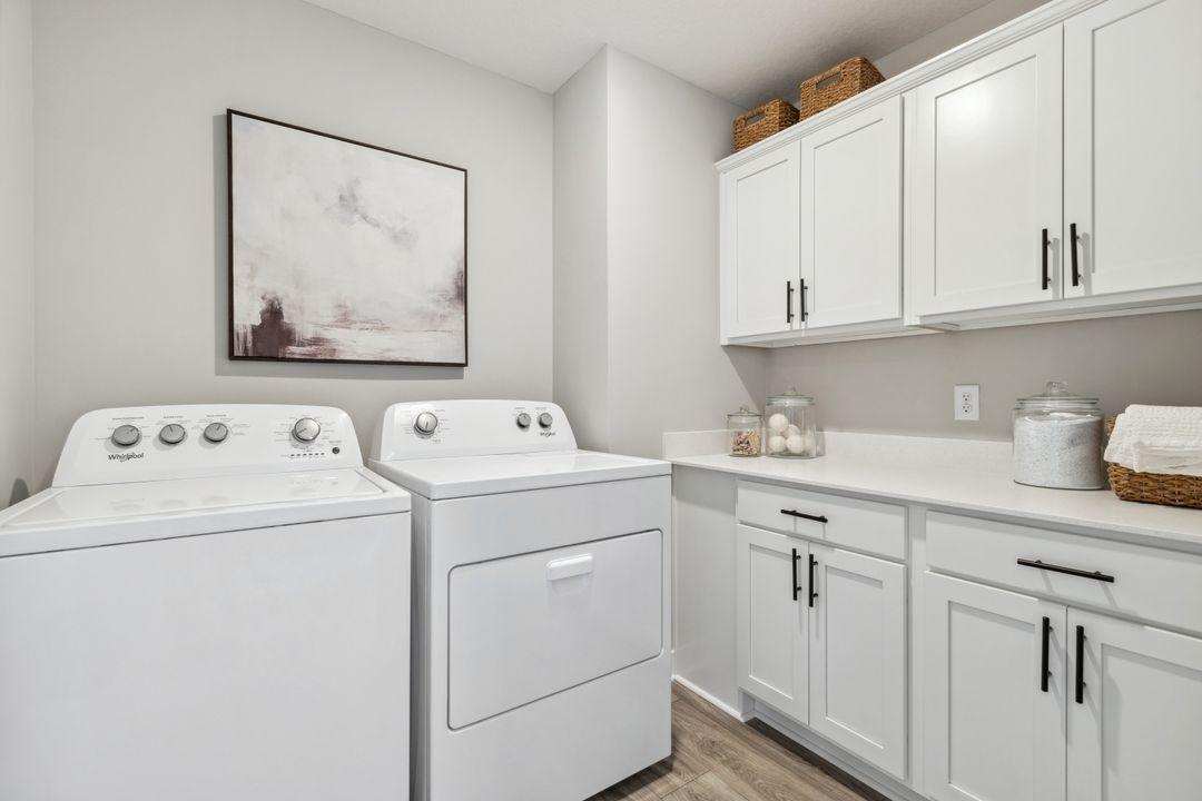 Convenient upper-level laundry room with cabinets for plenty of storage. Photo of a model home, color & options will vary.
