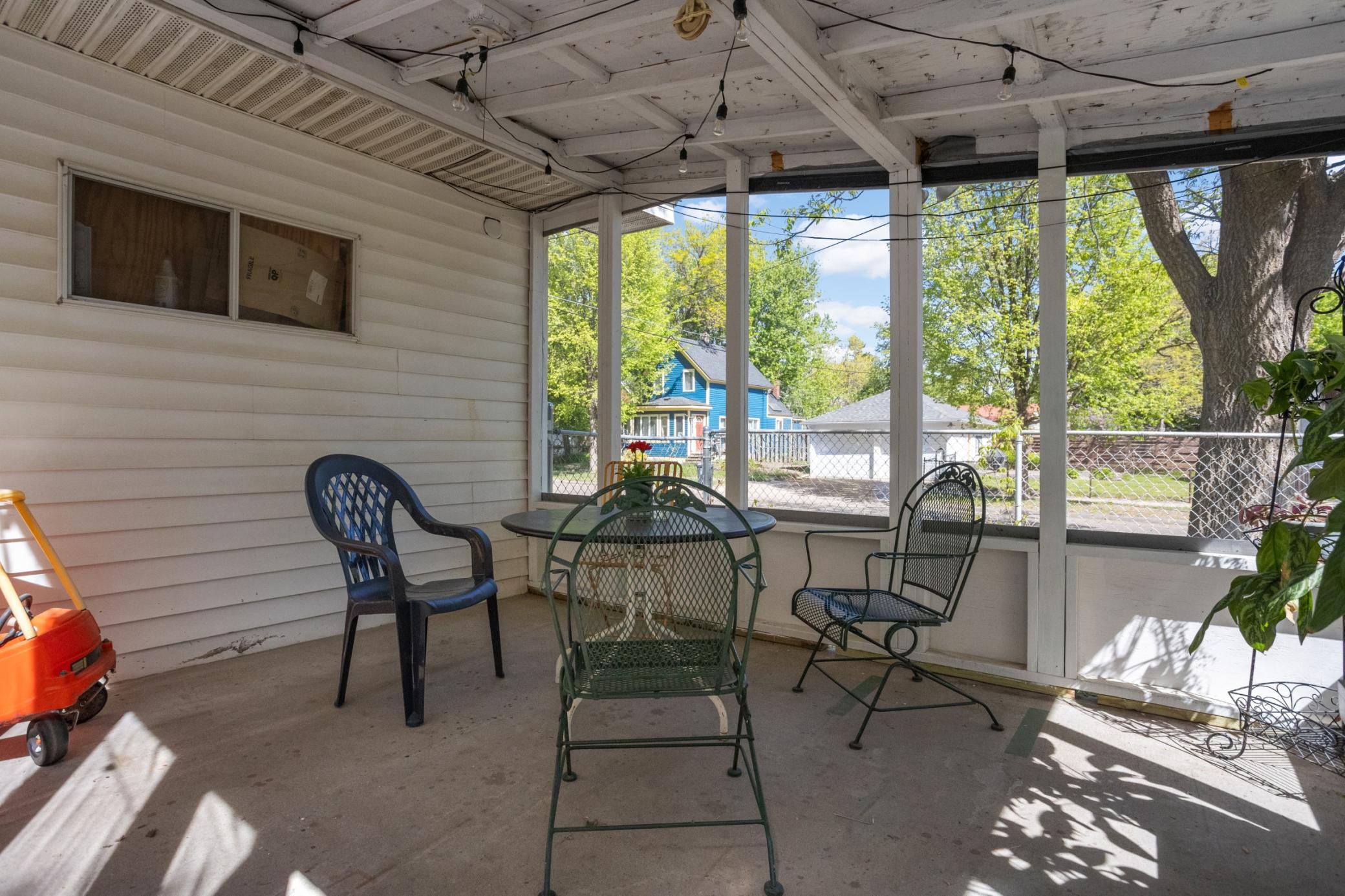 Backyard screened-in porch offering the perfect blend of comfort and outdoor living—ideal for relaxing evenings, entertaining guests, and enjoying peaceful views of the surrounding yard without the bugs.
