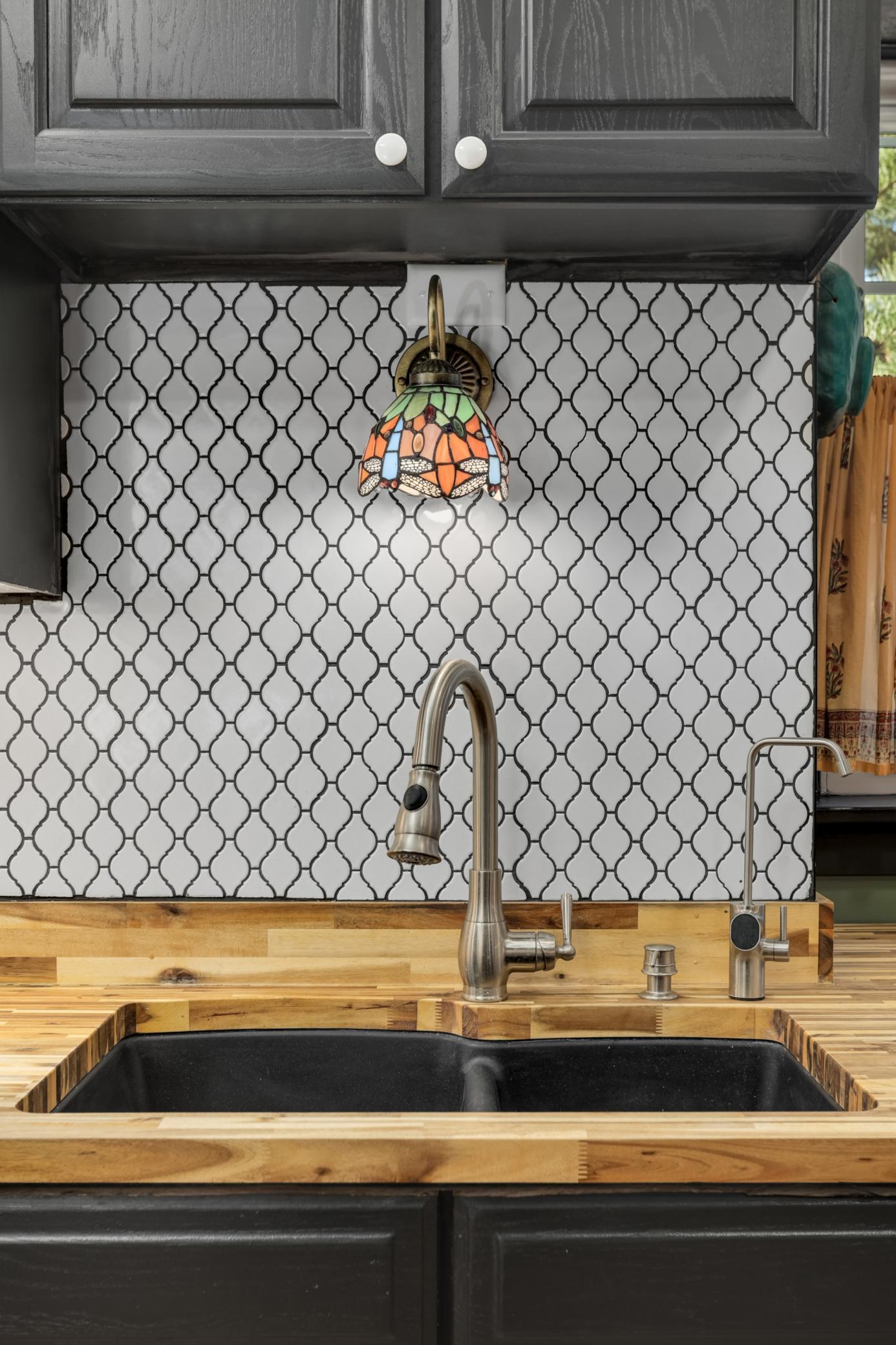 Stylish tile backsplash that ties together the countertops and cabinetry with a cohesive finish.