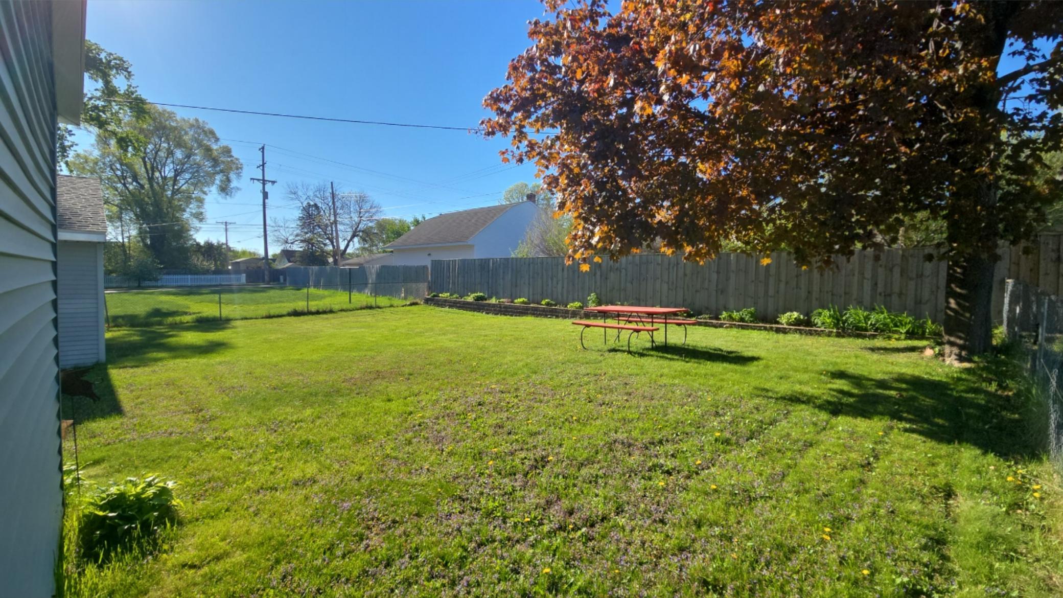 Spacious back yard with mature tree, perennials, and fully fenced.