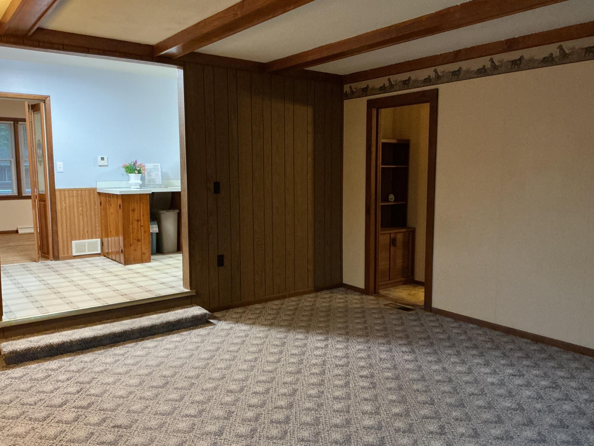 View of family room set off the primary bedroom and the eat in kitchen. Beamed ceilings add charm.