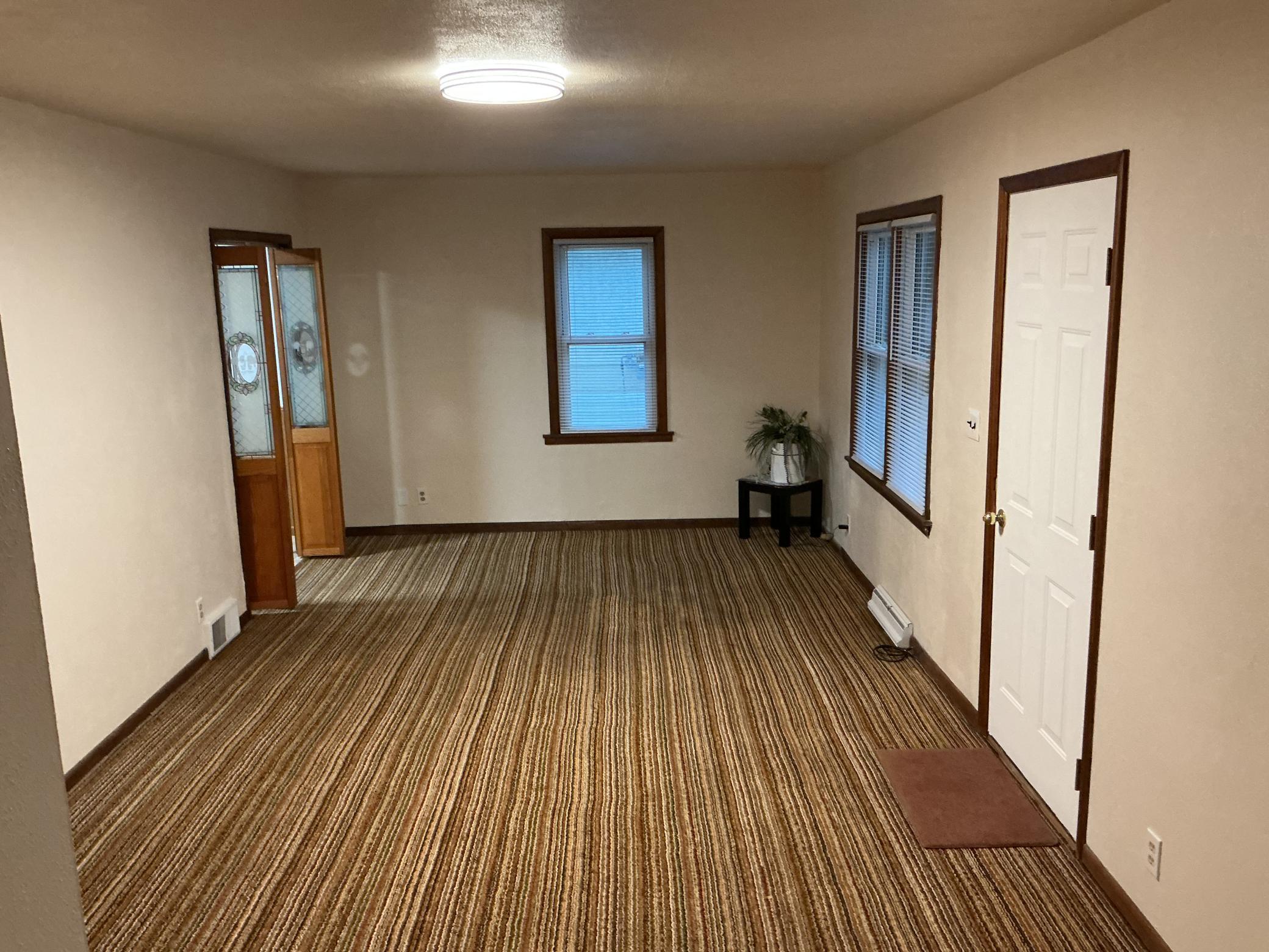 This spacious living/dining room is located at the front of the home and features hardwood floors waiting to be revealed!